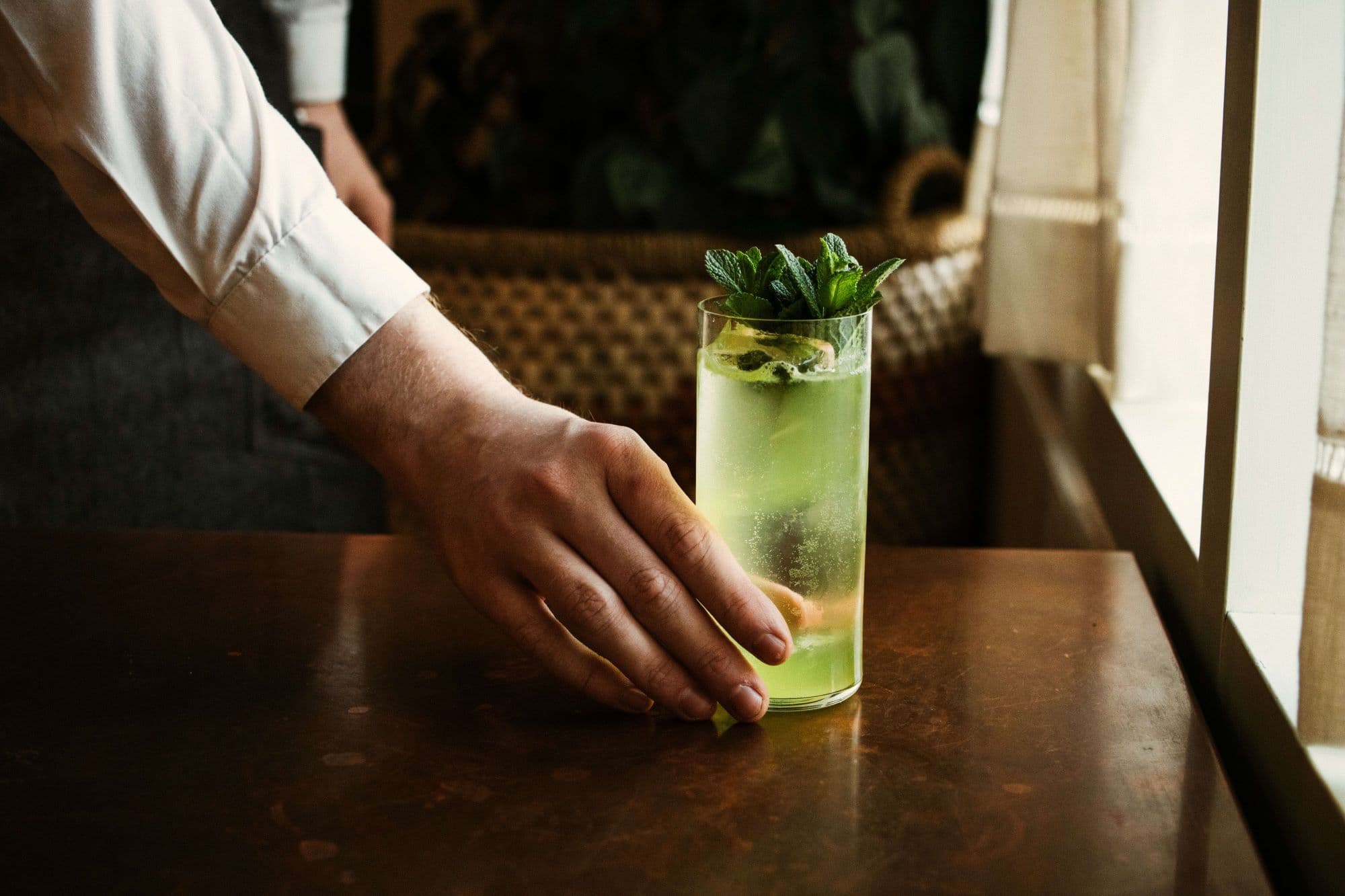 Personne tenant un verre de mojito